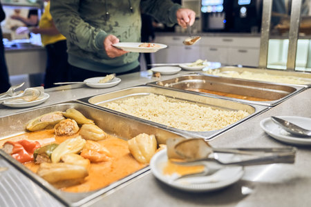A volunteer provides hot food for the poor. The concept of food in a charity canteen. With space to...