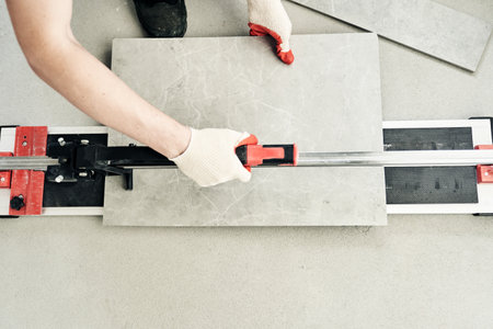 The master machine cuts the tile into two parts. A machine for cutting large ceramic tiles into smaller tiles with precise dimensions. High quality photoの写真素材
