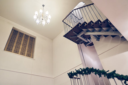Elegant and modern staircase with black metal handrails and wooden steps in a luxurious penthouse with minimalist decor. High quality photoの写真素材