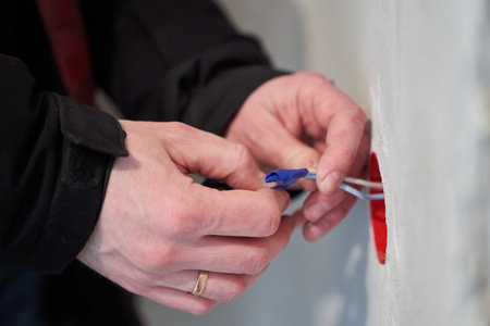Insulation of wires. An electrician working on a home electrical system installs a wall outlet. High quality photoの写真素材