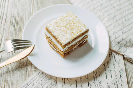 Honey cake in a white saucer on the tableの写真素材