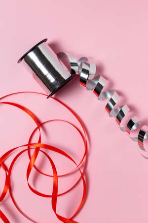 Close-up of ribbon for wrapping gifts on a pink background, gift wrapping, holidaysの写真素材