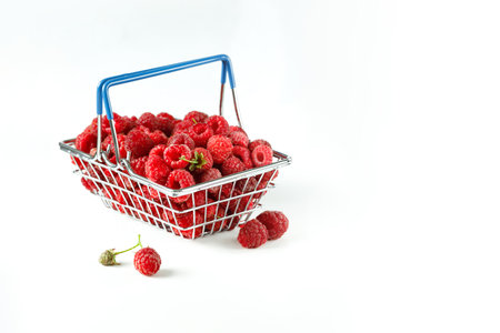 Mini grocery shopping basket with fresh raspberries on a white background. Food photoの写真素材