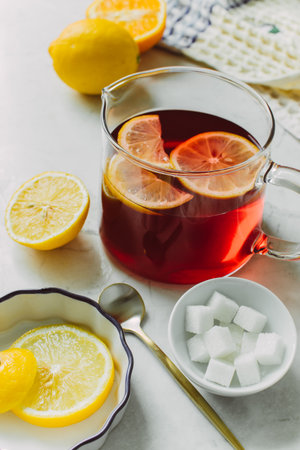 Pitcher of fresh lemon iced tea with filled glass on a rustic white backgroundの写真素材