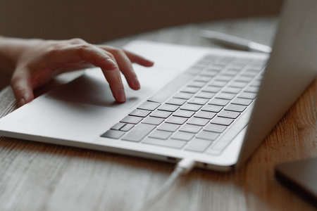 The girl works at home for a laptop. Hand on the touchpadの写真素材