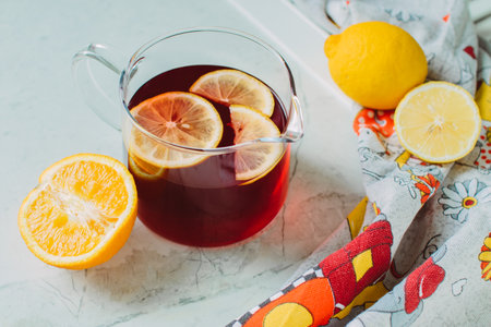 Pitcher of fresh lemon iced tea with filled glass on a rustic white backgroundの写真素材