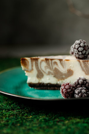 Cheesecake with chocolate flavor is on a plate with blackberries.の写真素材
