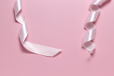Pink ribbon for gift wrapping on pink backgroundの写真素材