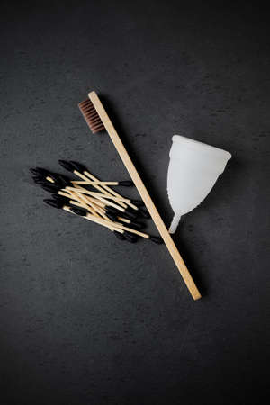 Biodegradable ear sticks, toothbrushes and menstrual cup on a plain backgroundの写真素材