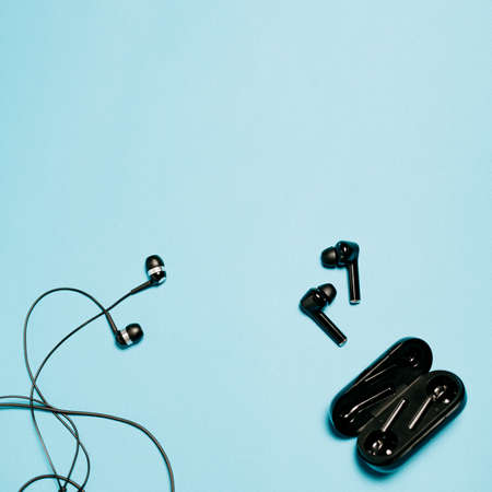Wired and wireless bluetooth headphones on a blue backgroundの写真素材