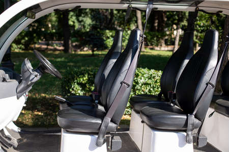Small car for transporting people around the golf course. Open car salon.