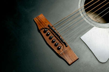 Guitar black acoustic detail close-up of strings and soundboard