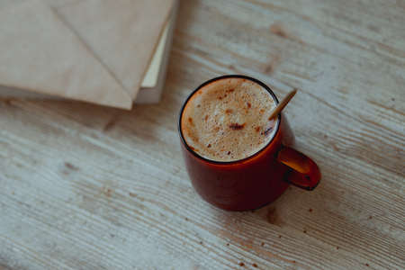 Coffee in a glass cup and morning mail stand on a wooden table.の写真素材