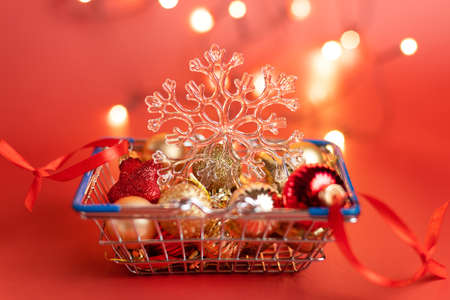 Basket of Christmas toys on a red background - balls, stars and snowflake, red and goldの写真素材