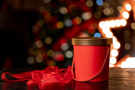 Red christmas gift box and wrapping ribbon on bokeh background. High quality photoの写真素材
