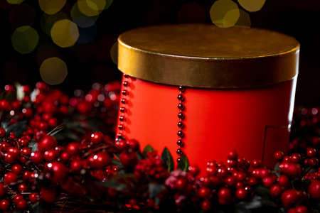 Christmas red box and decorations on the Christmas tree on a dark background with bokeh. High quality photoの写真素材