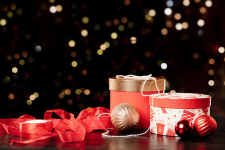 Christmas gift boxes, packing tape and balls on bokeh background, new year attributes. High quality photoの写真素材