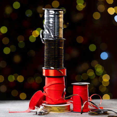 Christmas different ribbon spools for decorating gifts on a dark background with bokeh. High quality photoの写真素材