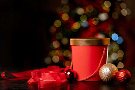 Red christmas gift box and wrapping ribbon on bokeh background. High quality photoの写真素材