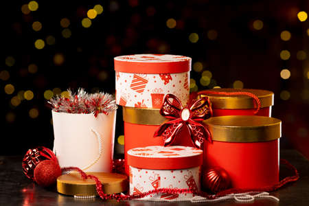 Christmas gift boxes, packing tape and balls on bokeh background, new year attributes. High quality photoの写真素材