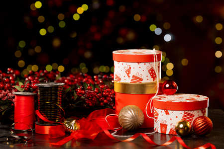 Christmas gift boxes, packing tape and balls on bokeh background, new year attributes. High quality photoの写真素材