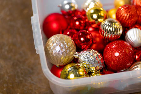 Lots of red and gold Christmas tree decorations in a box. Preparing for the new year, decor for the New Year treeの写真素材