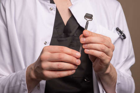 a male doctor in a white coat holding a manual therapy roller. High quality photoの写真素材
