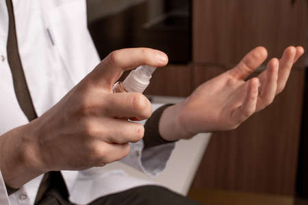 male doctor in a white coat holding an antiseptic. High quality photoの写真素材