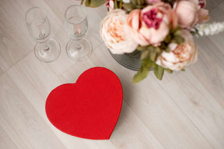 A gift box in the form of a red heart and a bouquet of flowers are on the floor. Valentine's Day - February 14th. view from above. high quality photoの写真素材