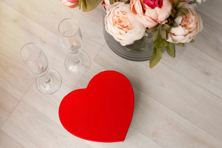 A gift box in the form of a red heart and a bouquet of flowers are on the floor. Valentine's Day - February 14th. view from above. high quality photoの写真素材