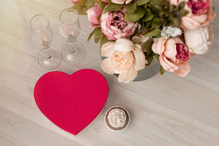 A gift box in the form of a red heart and a bouquet of flowers are on the floor. Valentines Day - February 14th. view from aboveの写真素材
