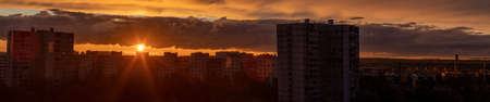 Sunset in the city of Moscow, the sun sets behind residential buildings, beautiful red cloudsの写真素材