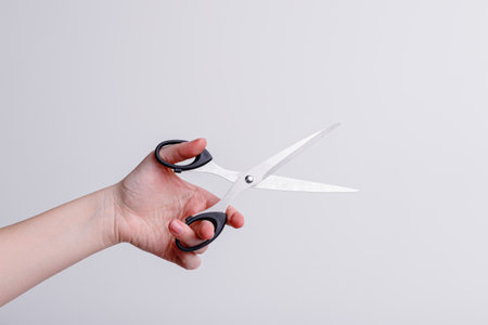 Stationery scissors in the hand of a girl on a white background. high quality photo