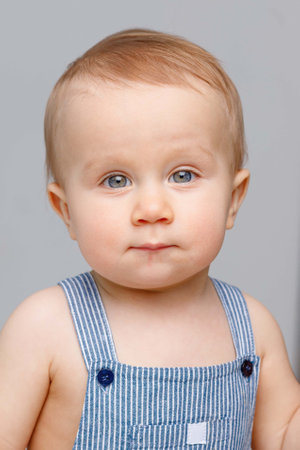Portrait of a baby with blue eyes on a light background, white background for advertising