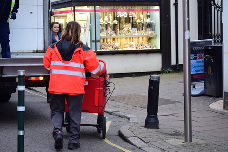 English postal lady pushing post truck in Barnstaple, Devonのeditorial素材