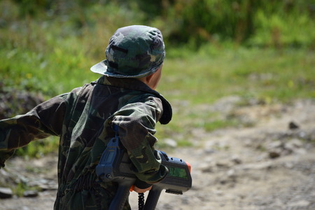 Young Boy playing laser tag while dressed in army style overallsの写真素材