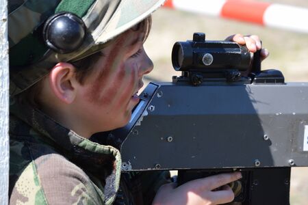 Young Boy playing laser tag while dressed in army style overallsの写真素材