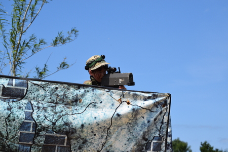 Young Boy playing laser tag while dressed in army style overallsの写真素材