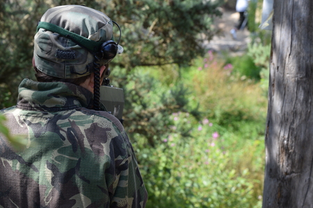 Young Boy playing laser tag while dressed in army style overallsの写真素材