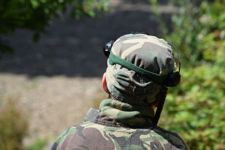 Young Boy playing laser tag while dressed in army style overalls