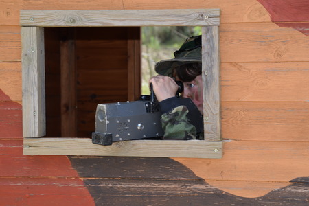 Young Boy playing laser tag while dressed in army style overallsの写真素材