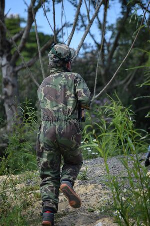 Young Boy playing laser tag while dressed in army style overallsの写真素材