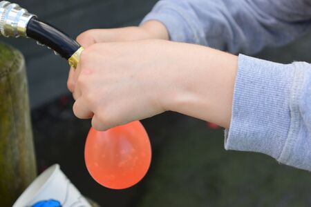 Young boys Have water fight with water bombsの写真素材