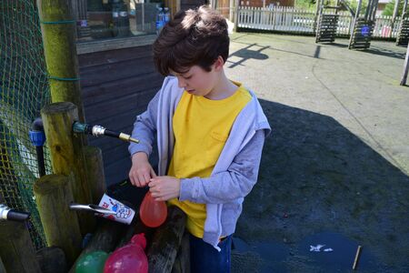 Young boys Have water fight with water bombsの写真素材
