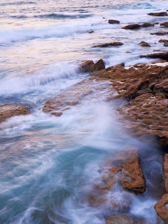 Stormy waves flow into rocksの写真素材