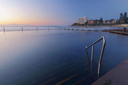 A calm blue ocean pool in the morning with no people swimming