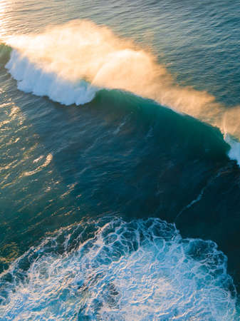Wave breaking under the morning light.の写真素材