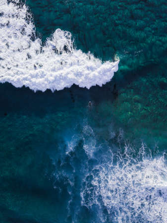Aerial view of one surfer about to hit the wave.
