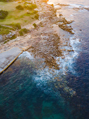 Sunlight hitting the rocks in the ocean. View from above.の写真素材