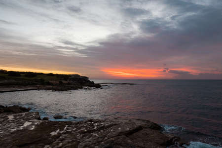 Red cloudy sky before the sunrise at Sydney coastline.の写真素材